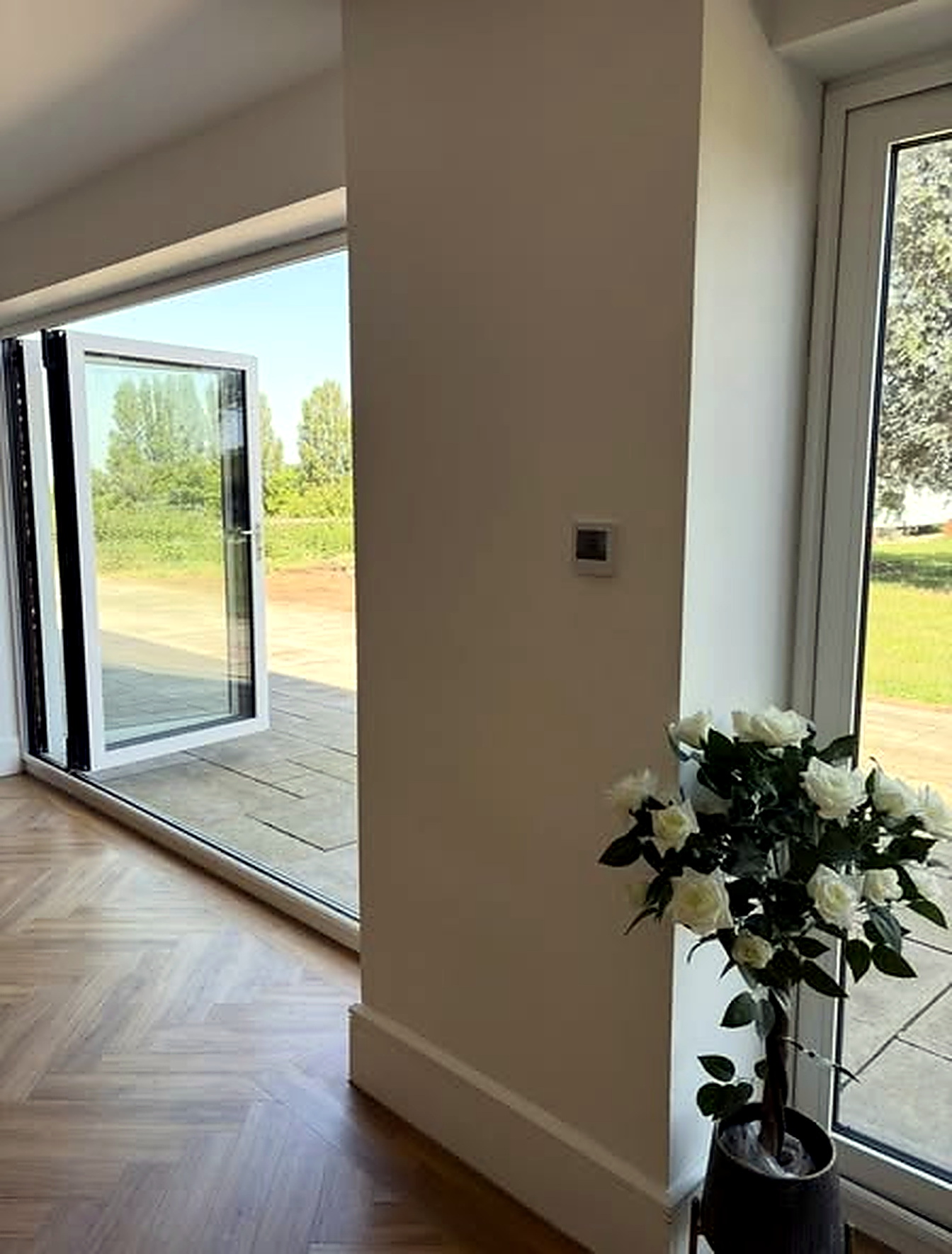 Bright entryway with flowers and open doors