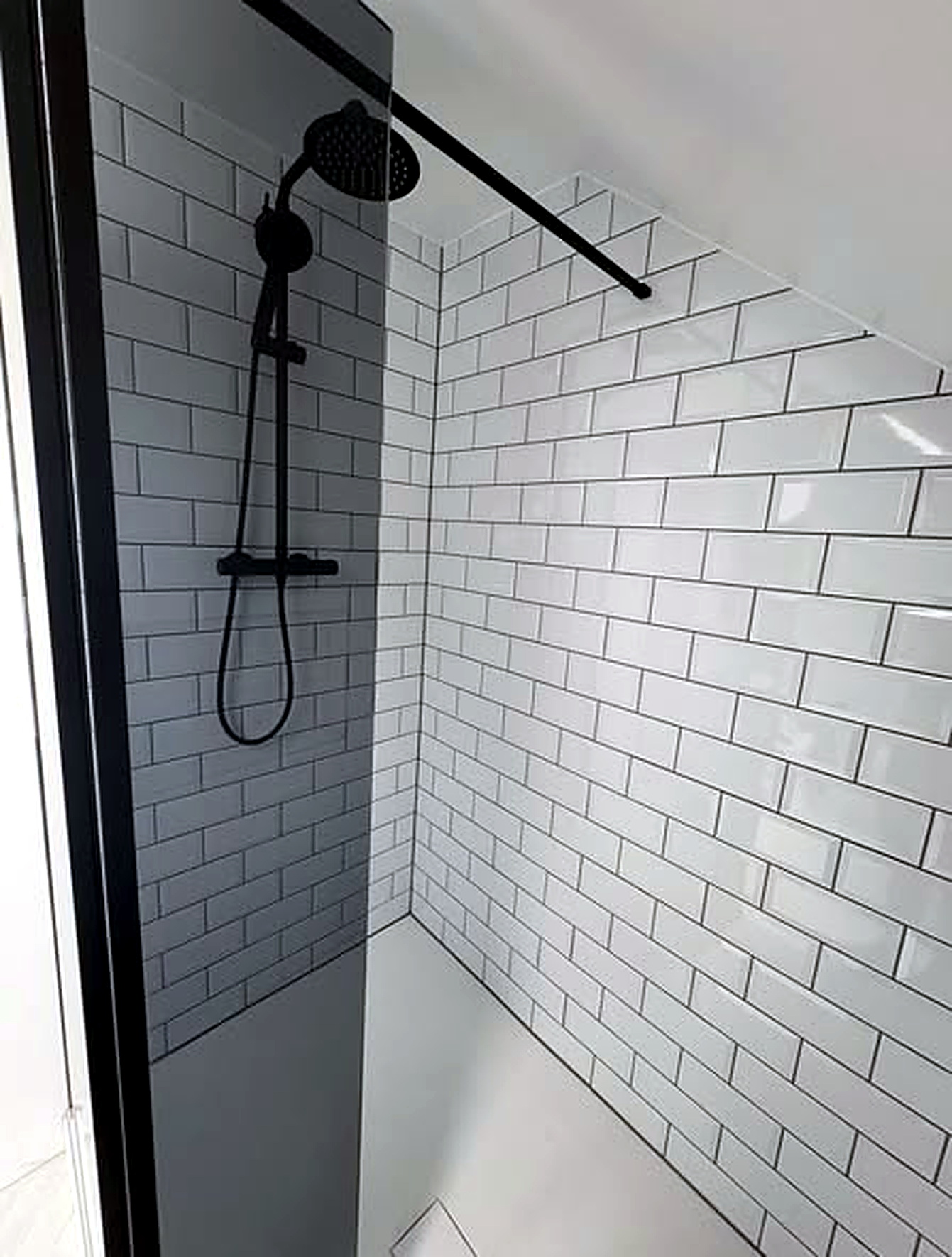 Clean white tiled shower area